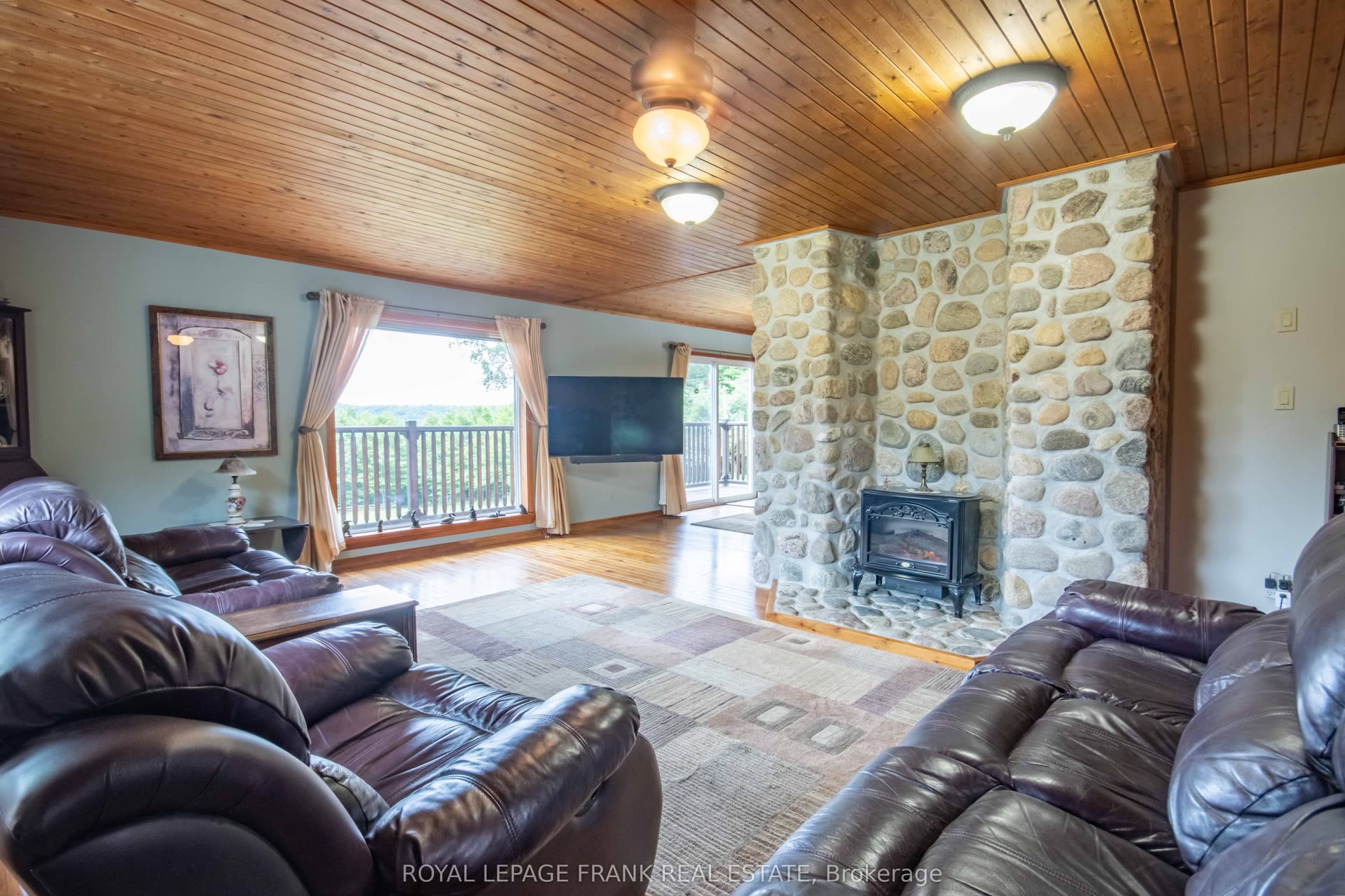 Living room with natural river-stone fireplace and pine ceiling
